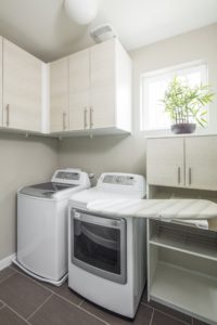 Modern space saving custom laundry room design with custom cabinets and pull-out ironing board