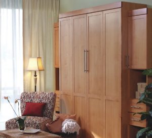 Professionally installed full size Murphy bed in medium wood with cabinet doors closed