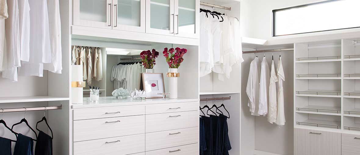 Custom closet design with drawers, glass doors, and shoe shelves