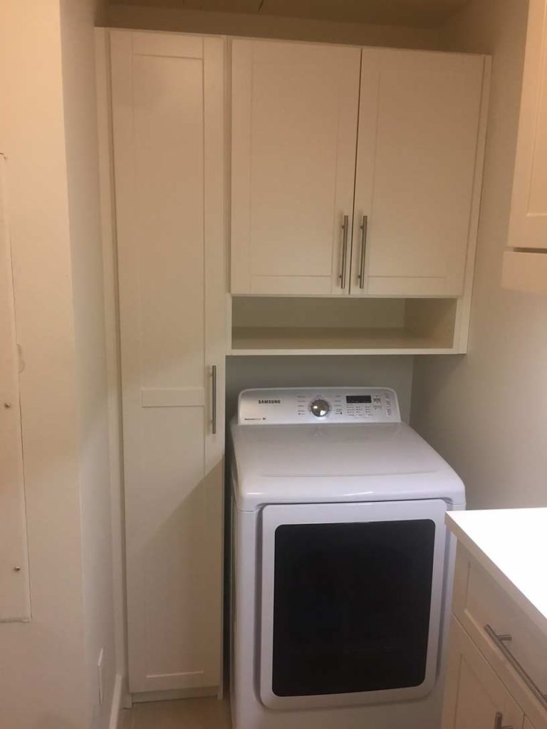 Modern space saving corner laundry room with custom cabinets overhead
