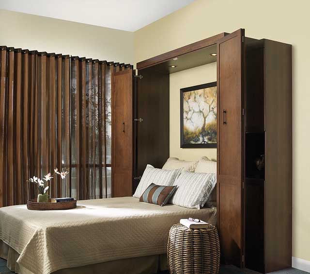 Guest room Murphy bed, comfortable pillows and bedding, dark wood cabinet