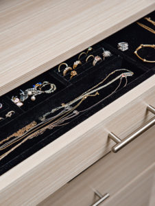 Dark velvet jewelry organizer set in light finished wood drawers with minimalist silver hardware