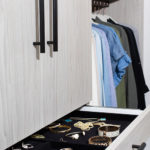 a grey drawer that pulls out shows accessories with clothes