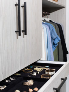 a grey drawer that pulls out shows accessories with clothes