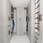 center view of a walk in closet with grey cabinets