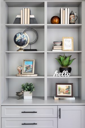 stylish grey book case with lots of thing inside