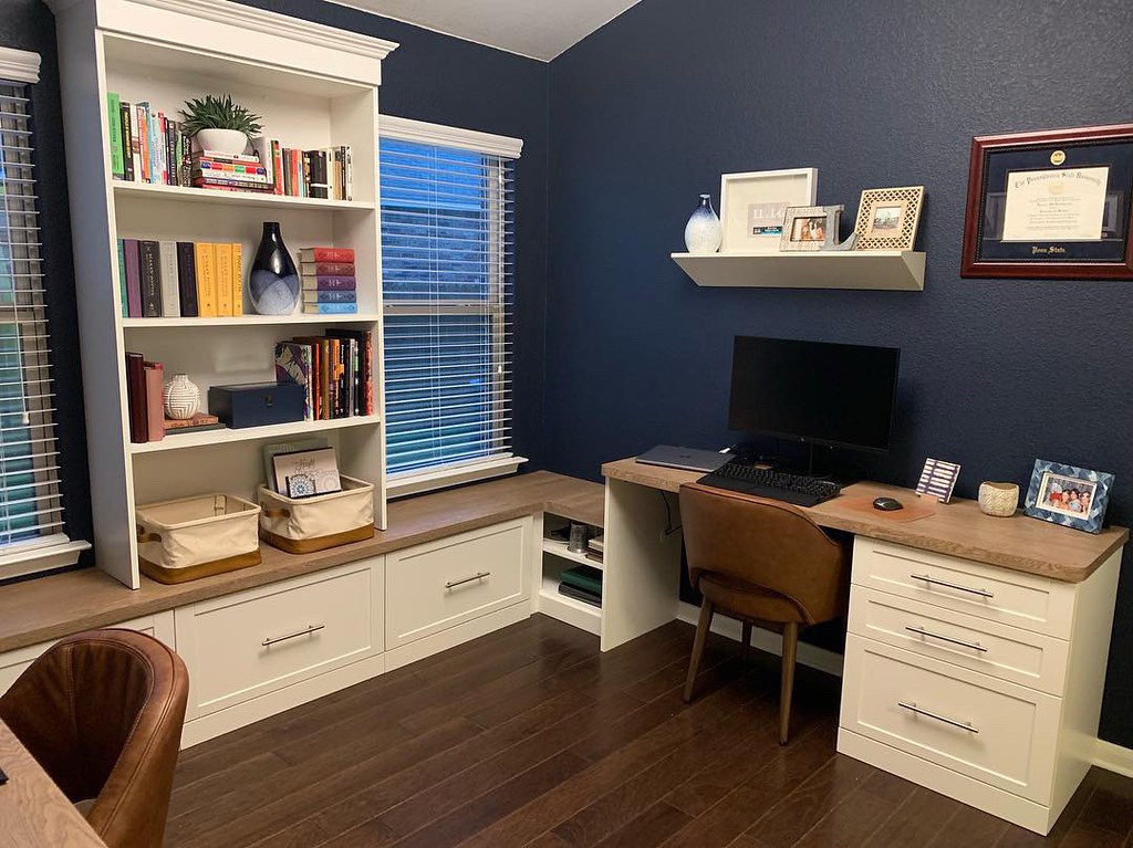 Home office space for two people. White desks for two sit back to back across the room from each other.