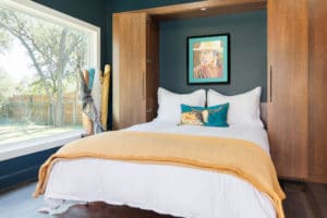 Previous office setup removed to reveal open Murphy bed. Bed receives plenty of natural light with a pop art print framed above bed within cabinet.