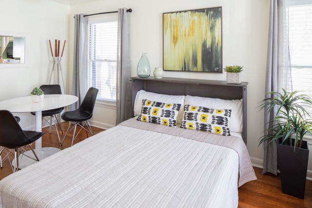 Modern full-size Murphy bed extended from gray cabinet provides an easily accessible guest space.