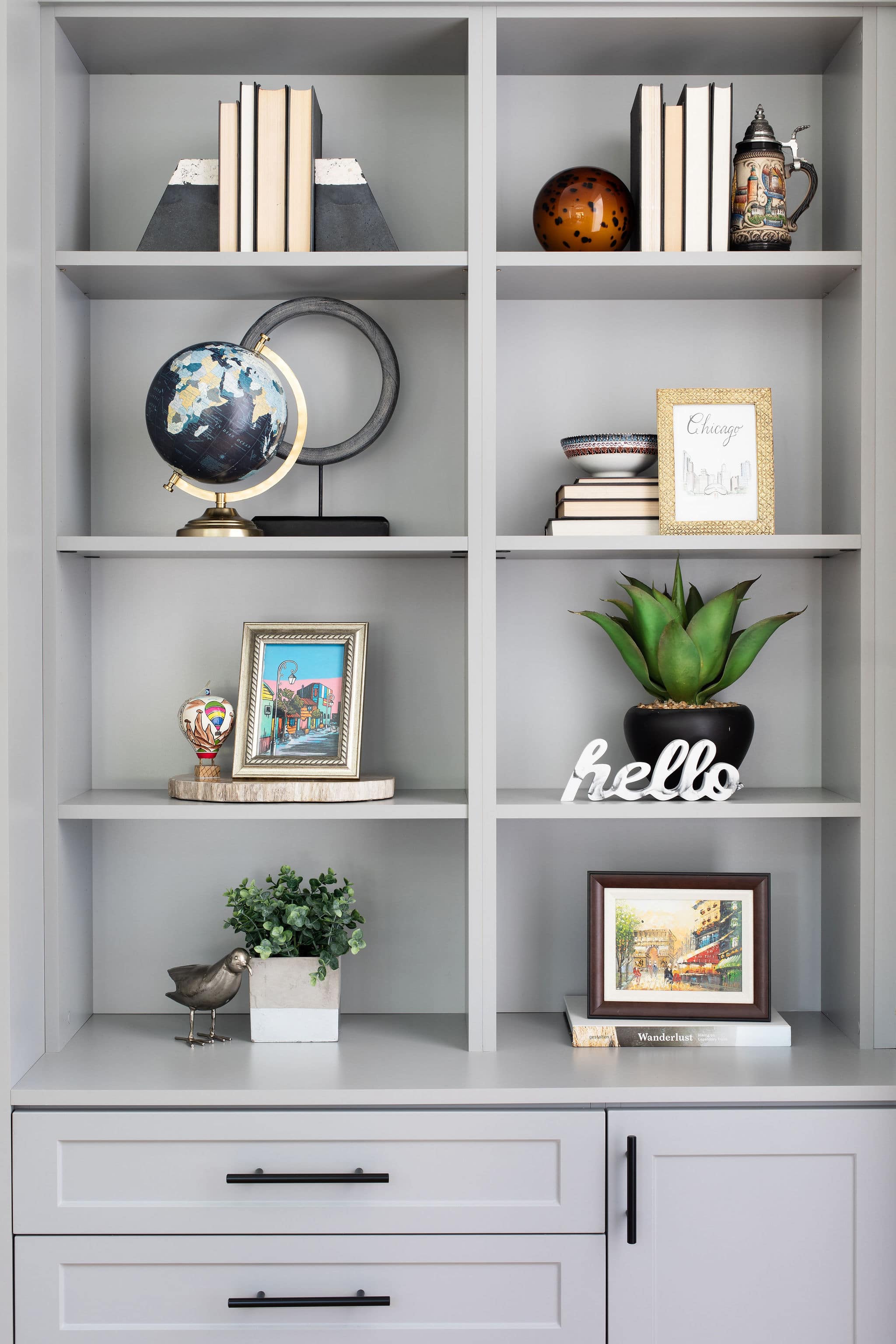 Decorative home office shelves housing a collection of curios, books and plants
