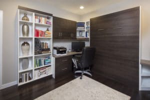 Image illustrating Murphy bed FAQ about making space in a home office. Bed folded away next to desk and shelves. 