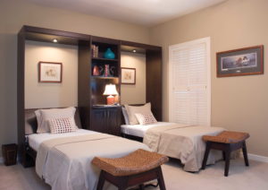 Twin Murphy beds folded out from tall dark wood cabinets - ready for a good night's sleep!