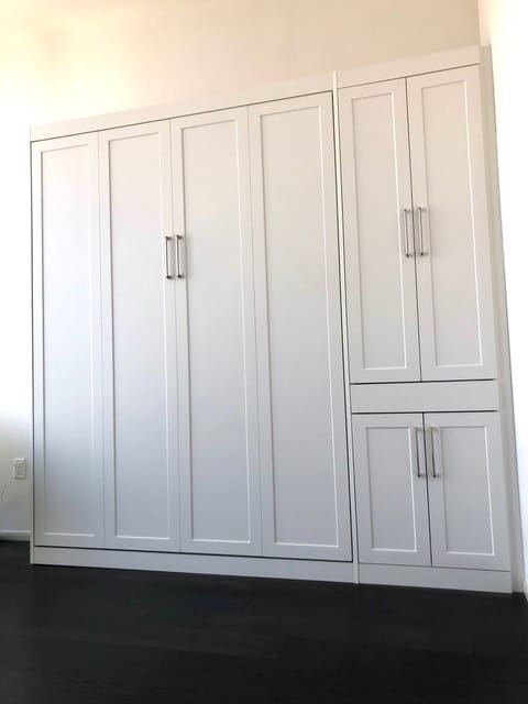 Tall white cabinets enclose a space-saving Murphy bed; compare with next image of Murphy bed folded out