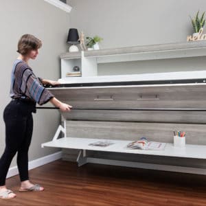 A gray washed wood drop down desk is a functional space saving feature for an guestroom.