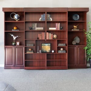 Sophisticated space saving Murphy bed closed behind classic custom cherry wood bookshelves..