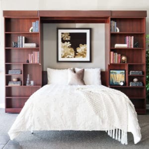 Sophisticated space saving Murphy bed between classic custom cherry wood bookshelves..