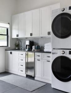 Joanna's midcentury modern style featuring modern conveniences that make it operable and comfortable. She achieved this look by combining classic cabinet finishes with a white penny tile backsplash and dark grout.
