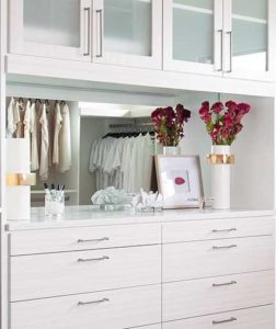 Modern white shelf in closet with built-in mirror, perfect for displaying jewelry and accessories.