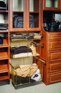 Wire basket clothing organizers in a custom wood shelving closet unit