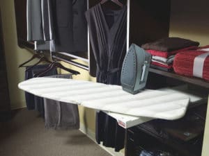 Folding ironing board stows away in custom closet shelving