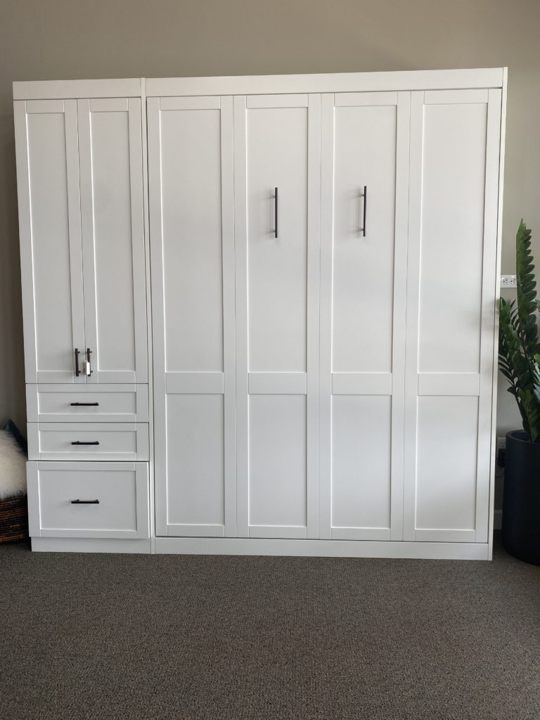 White Murphy closet bed closed featuring tall vertical cabinets.
