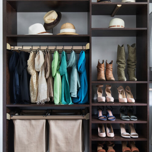 Custom closet with hampers and slide out pant rack.