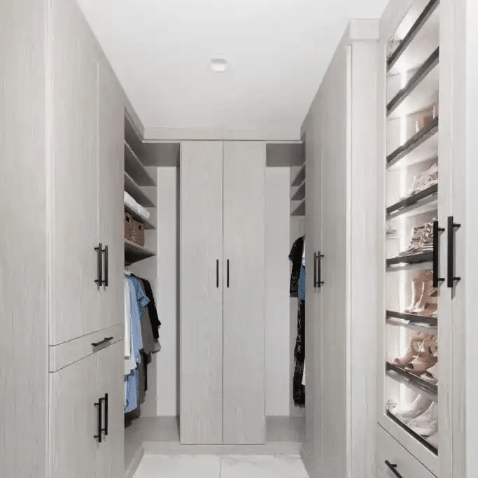 Floor to ceiling closet in weekend getaway with lots of closed storage and glass doors with lights inside.