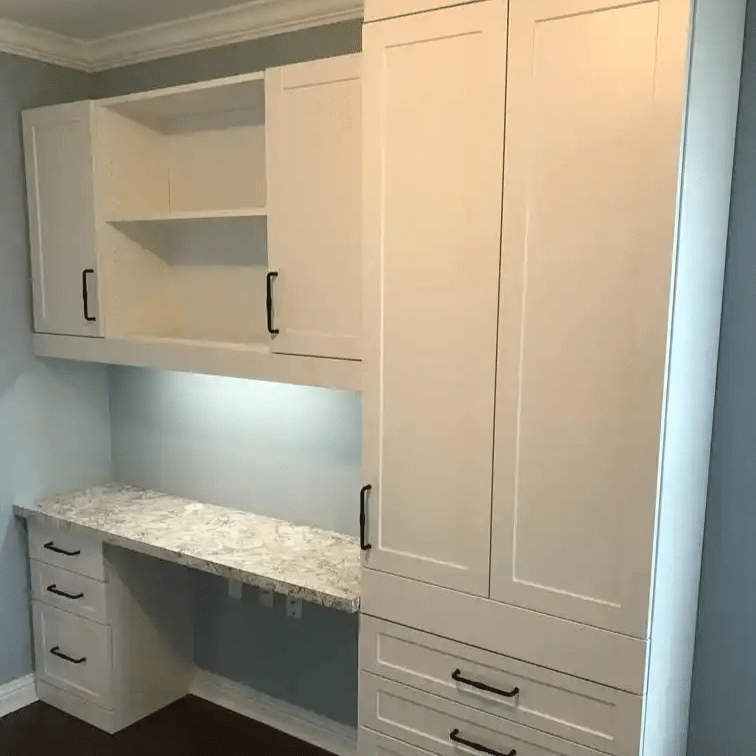 White shaker home office with task lighting and drop-down table.