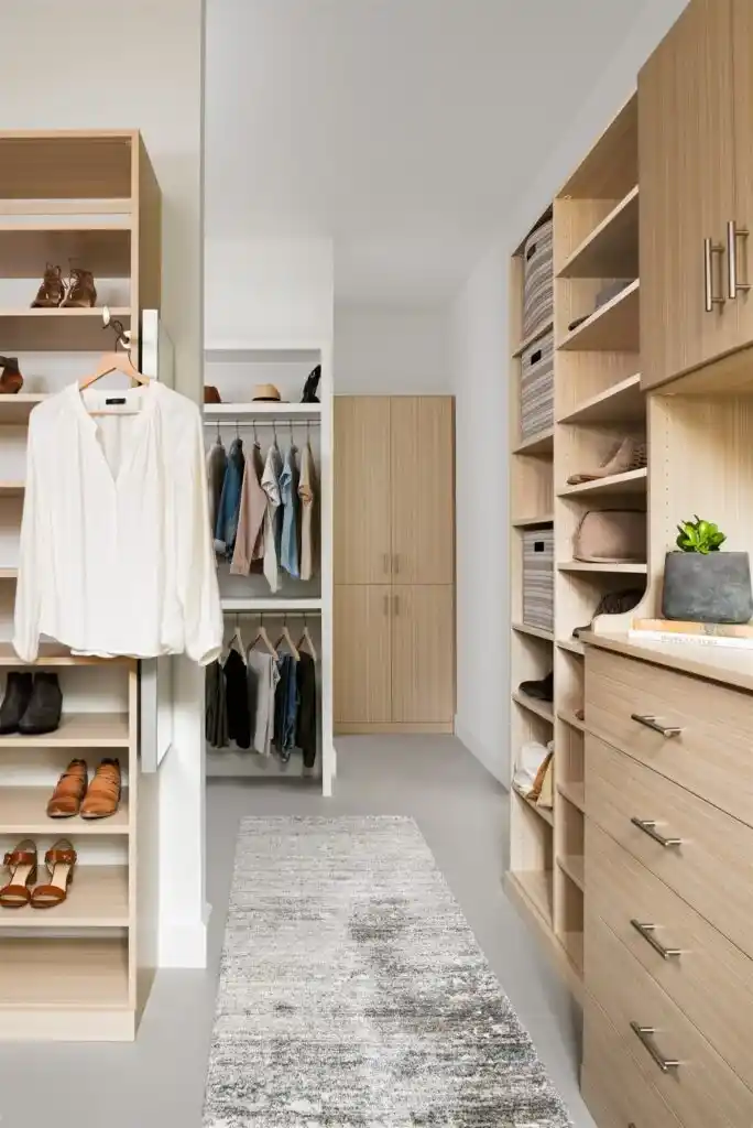 Walk-in closet in summer breeze with lots of shelving and valet rod.