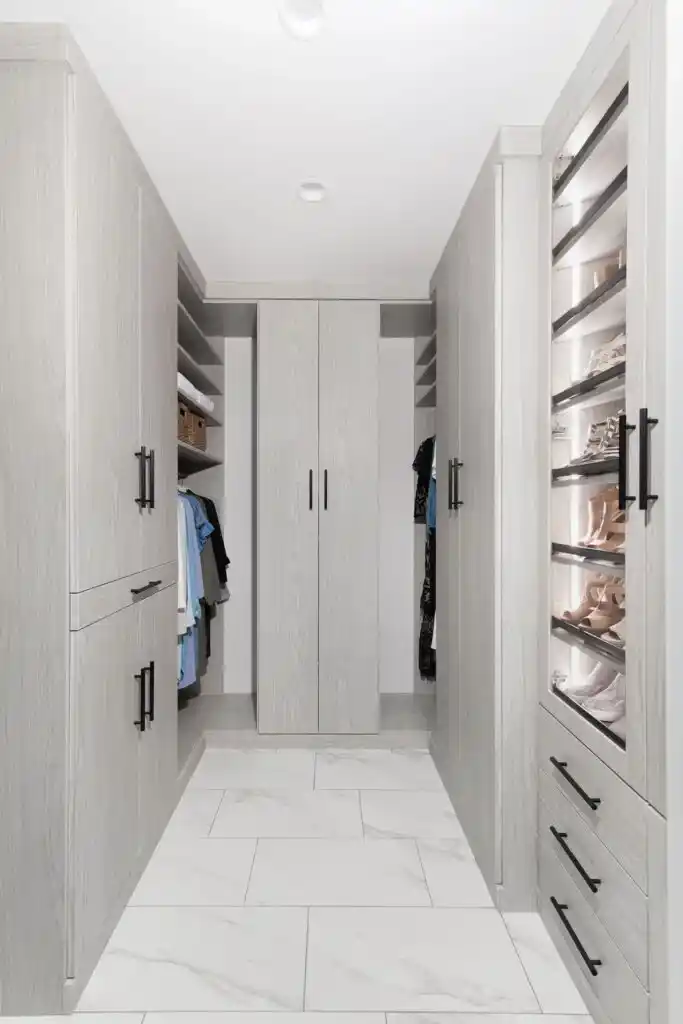 Floor to ceiling closet in weekend getaway with lots of closed storage and glass doors with lights inside.