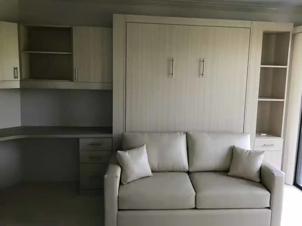 Panel bed in white chocolate with a sofa in front of it, with a side cabinet on one side and an office on the other.