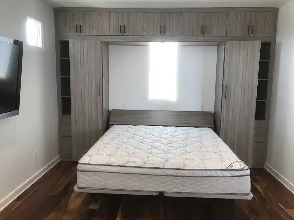Queen Murphy bed in contemporary Sandalwood with side cabinets on either side, cabinet storage above, with a floor to ceiling design.