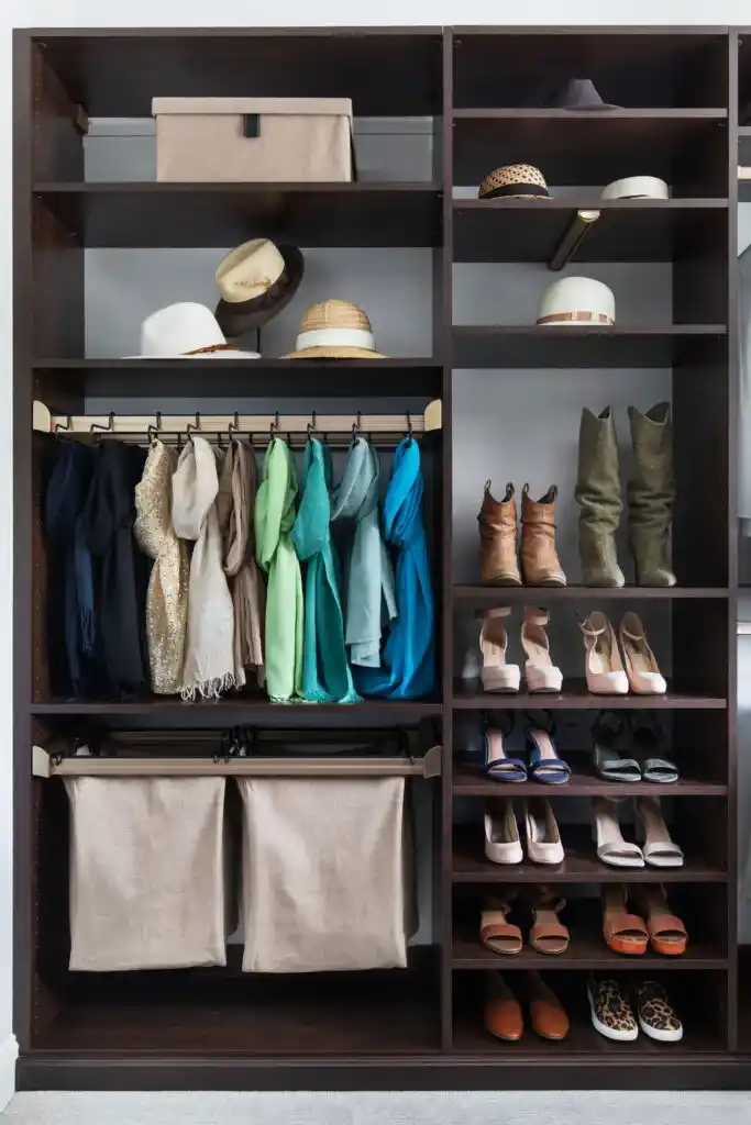 Chocolate traditional walk-in closet with ironing board, wardrobe rail, and island in the center.