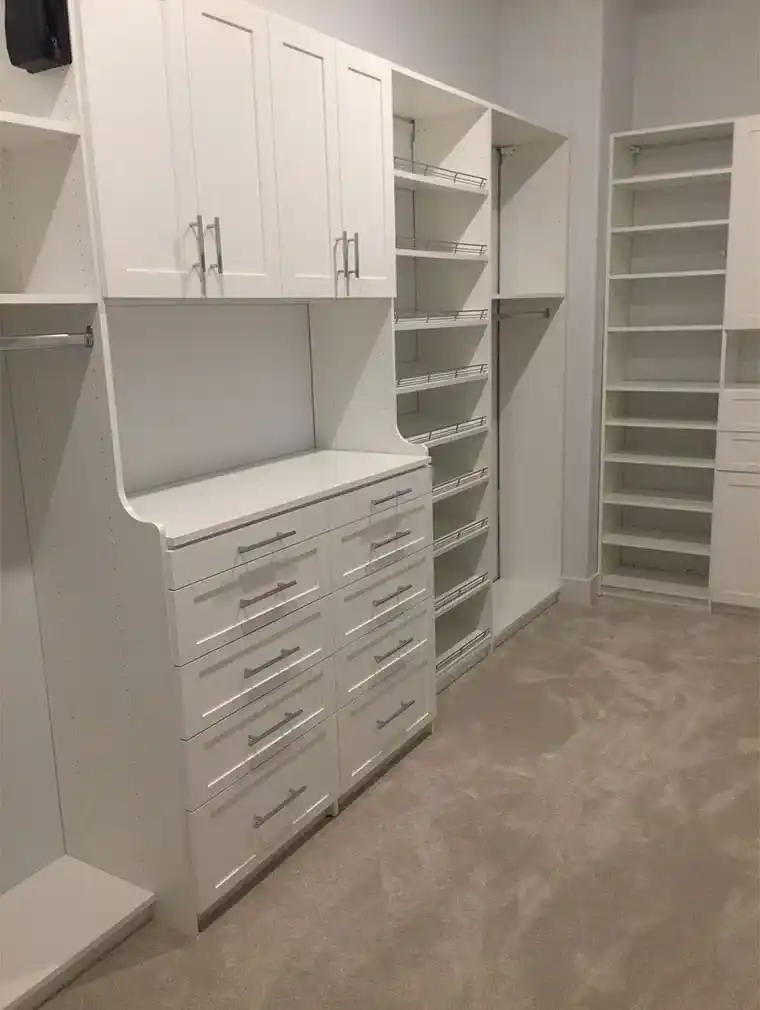 White shaker closet with wardrobe lifts and shoe shelves.