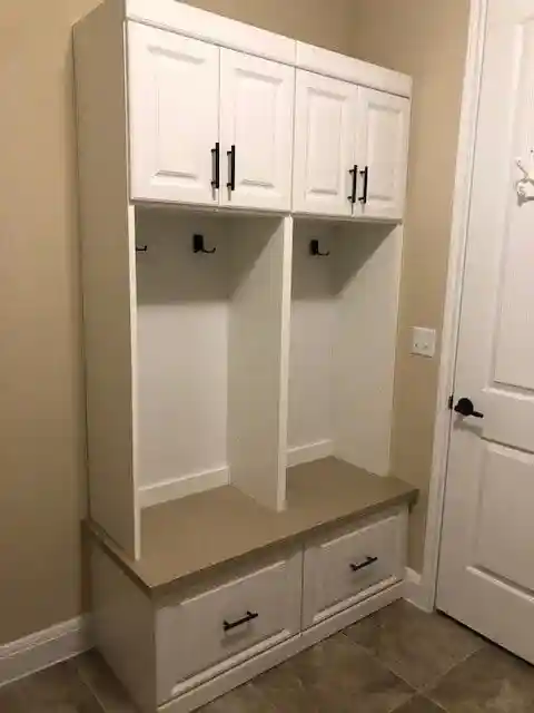 White traditional mudroom with drawers below and cabinets on top.