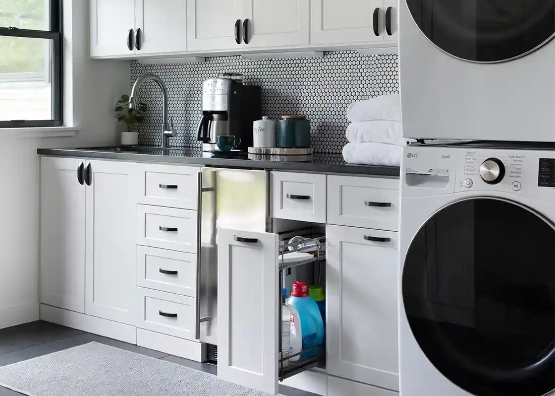 White shaker utility room with glide out cabinet.